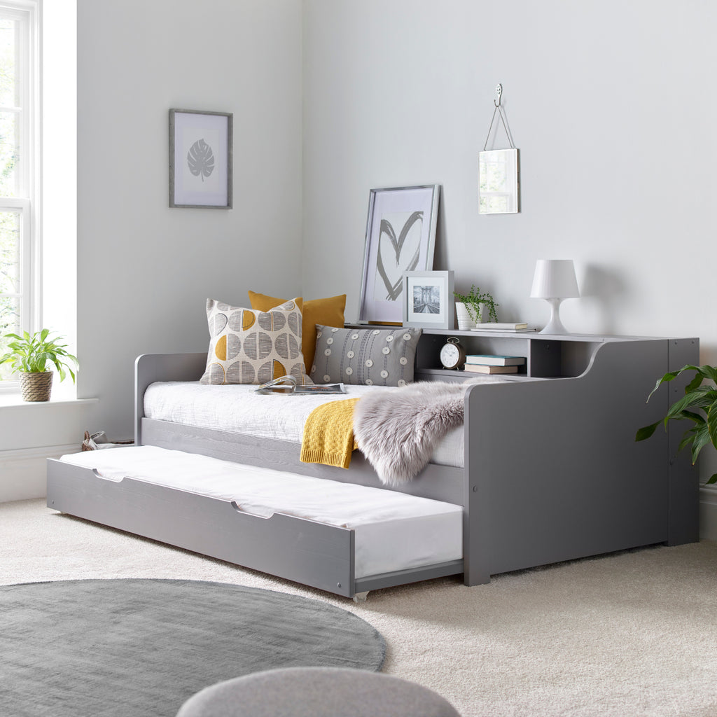 Tyler Pine Guest Bed With Trundle in grey. Shown in furnished room with trundle open.