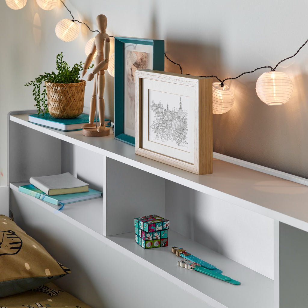 Oilver Solid Wood Bunk Bed in white in furnished room, upper bunk shelving detail