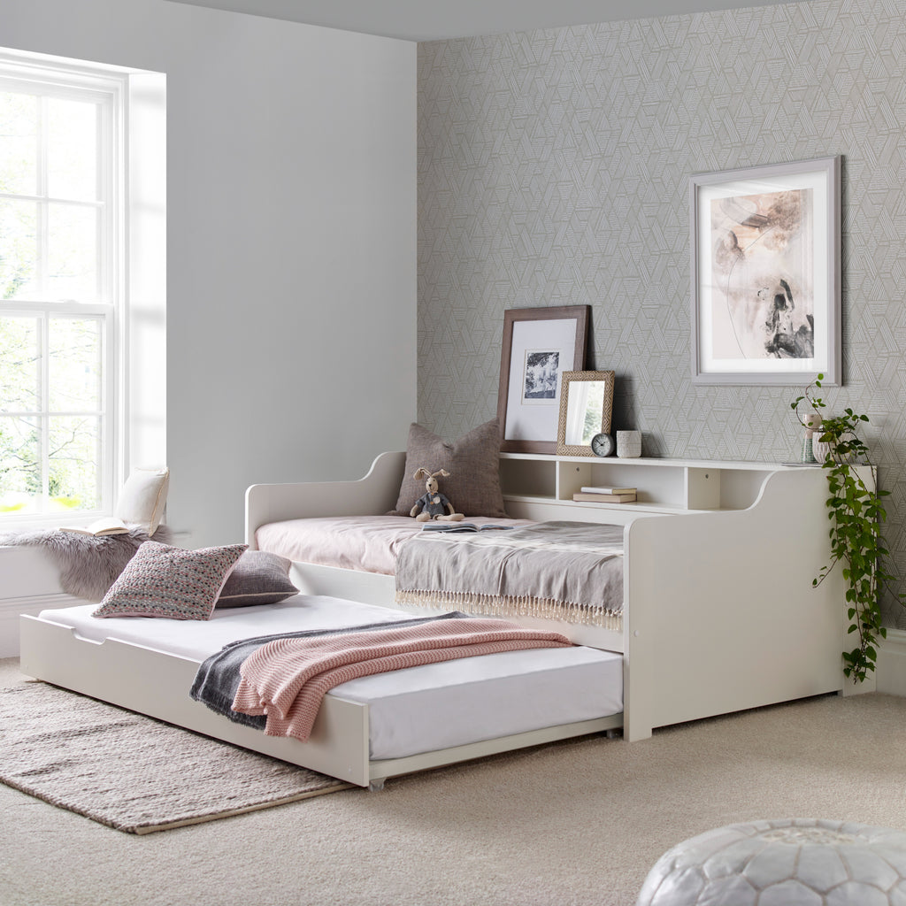Tyler Pine Guest Bed With Trundle in white. Shown in furnished room with trundle open and dressed