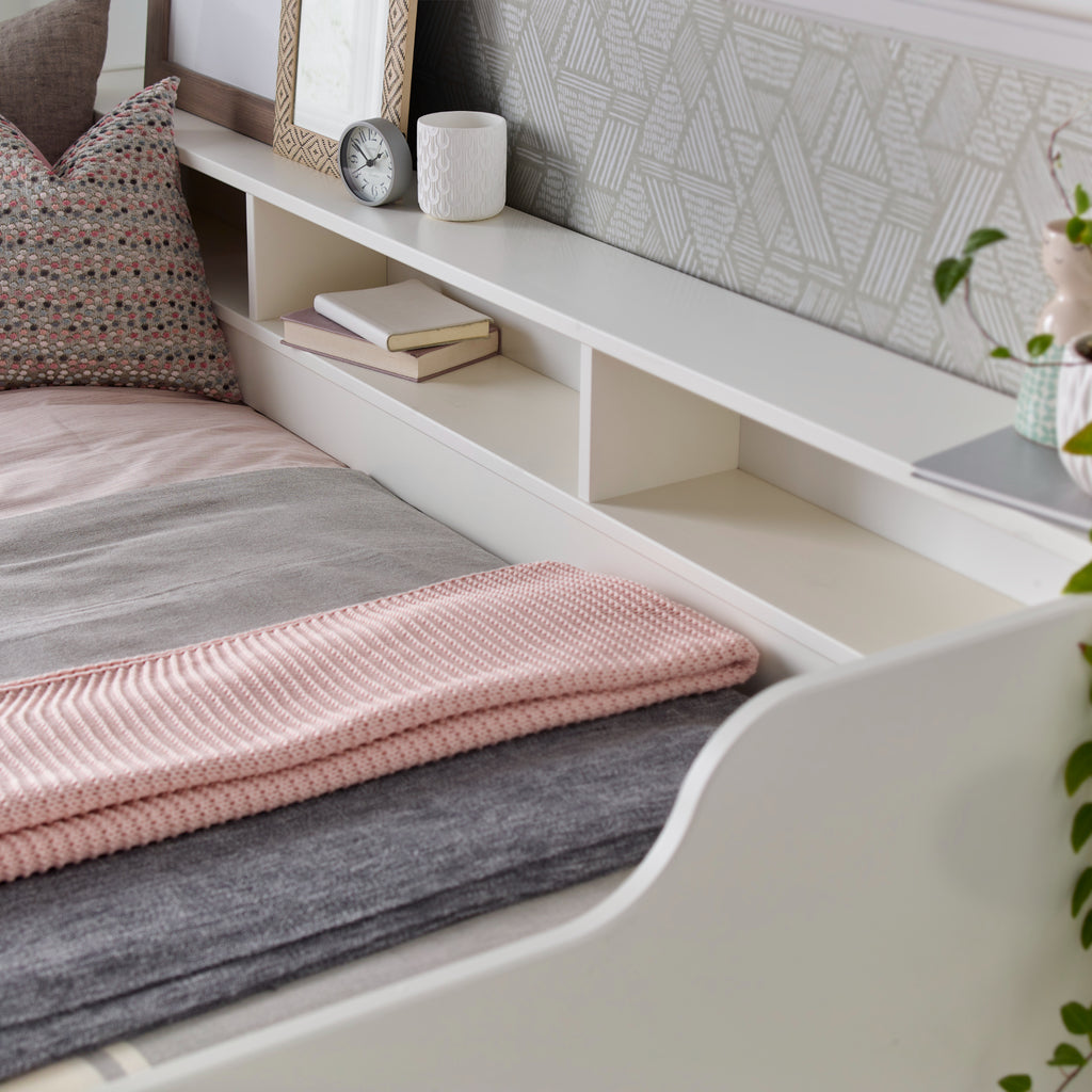 Tyler Pine Guest Bed With Trundle in white. Shown in furnished room, close up on built-in shelves detail
